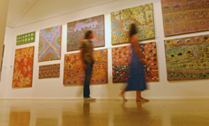 Immagine di due persone sfocate che osservano delle opere d'arte