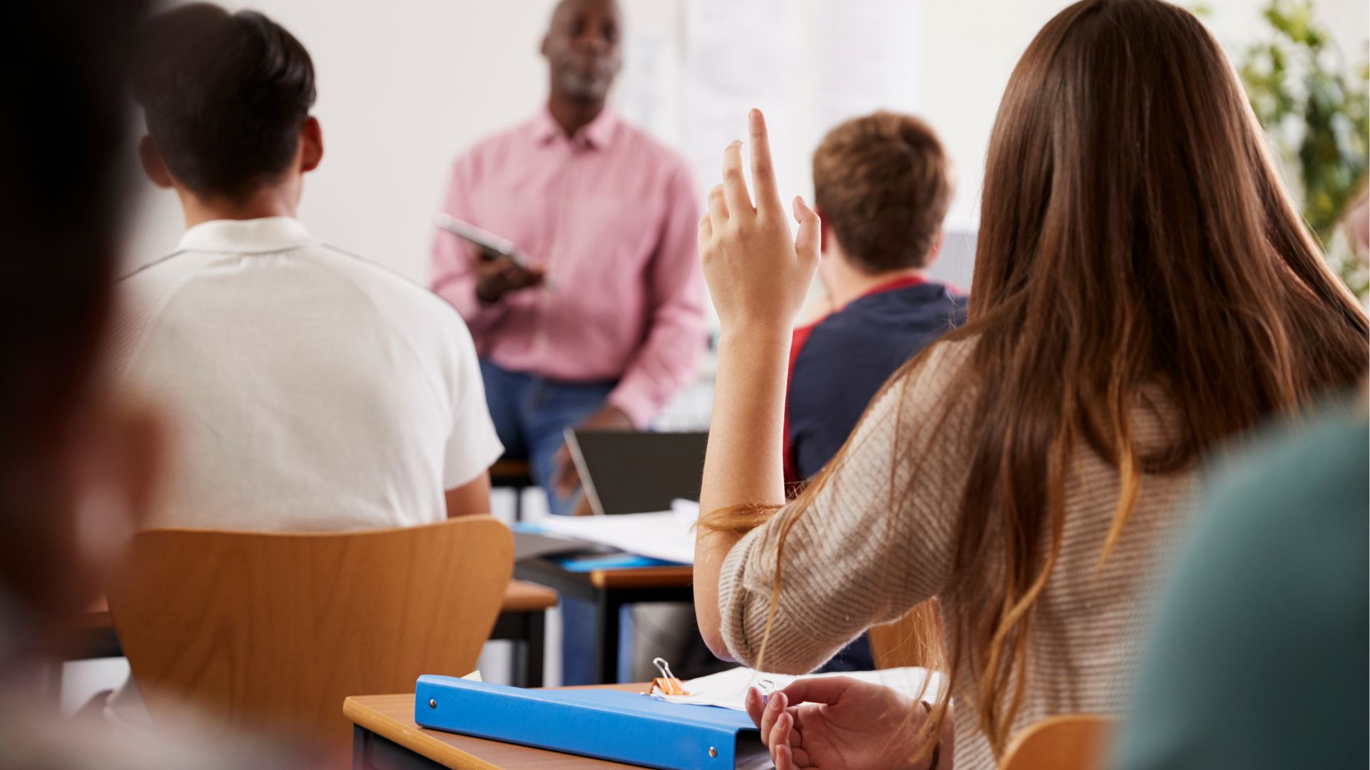 Alunna che alza la mano a lezione