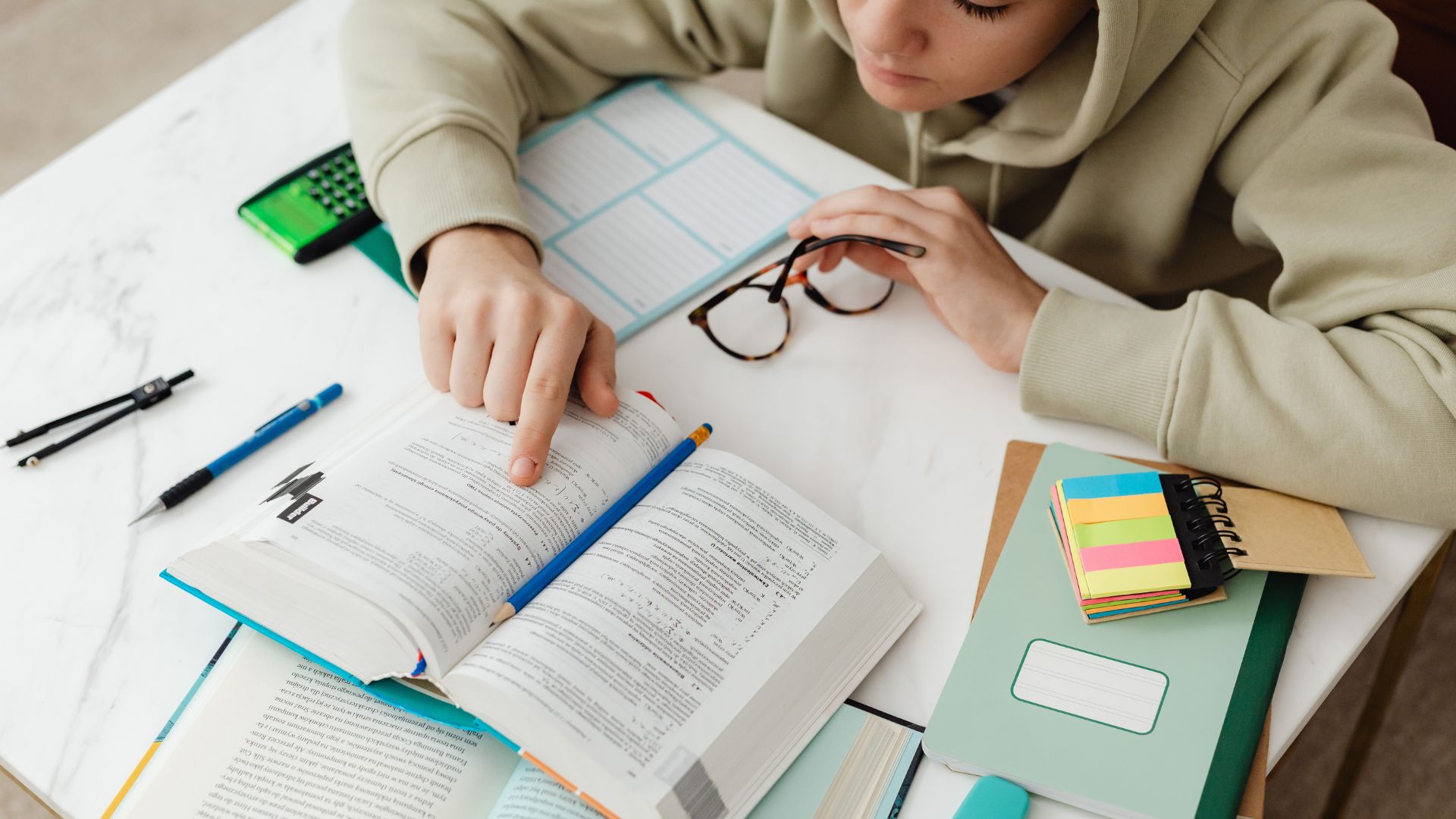 Ragazza che legge un manuale e con intorno post-it, quaderni ed etichette